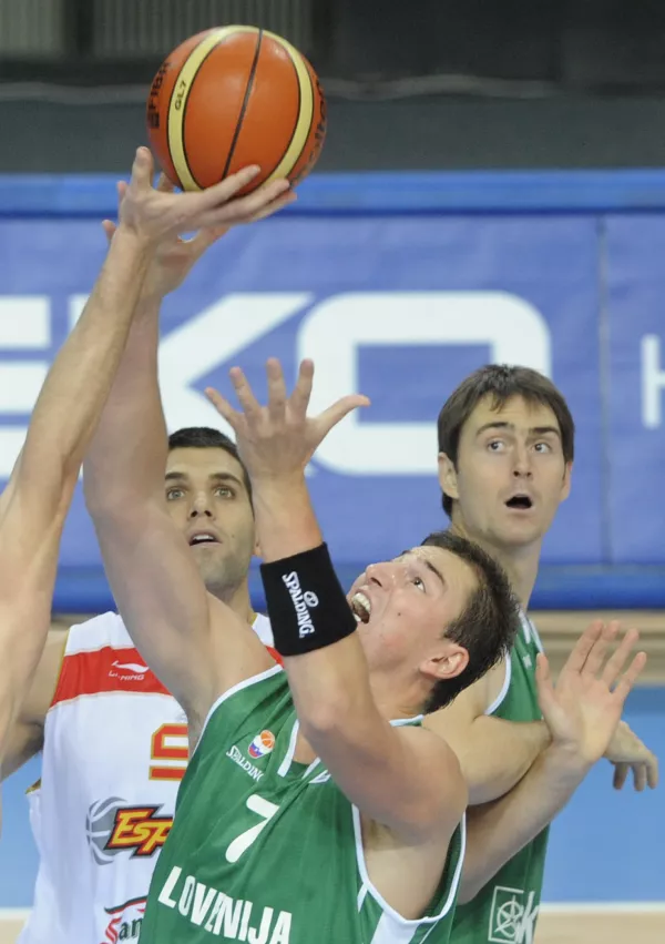 Slovenia's Primoz Brezec, center, reaches for the ball, as Spain's Felipe Reyes, left, and Slovenia's Domen Lorbek look on during their EuroBasket 2009, European Basketball Championships group C match in Warsaw, Wednesday, Sept. 9, 2009. (AP Photo/Alik Keplicz) / Foto: Alik Keplicz