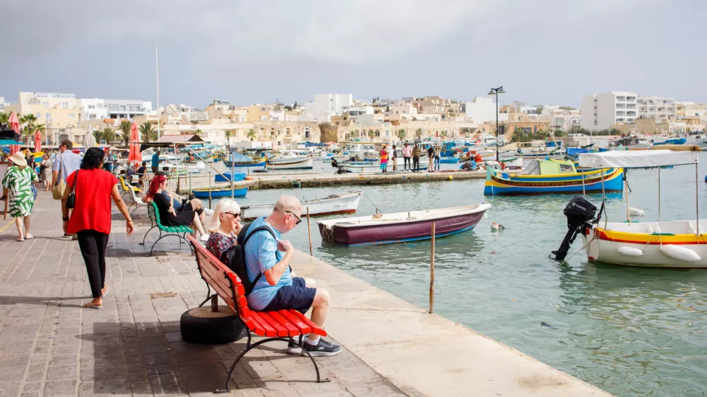 Marsaxlokk, Malta - 9th of October, 2024: Tourists walking around and enjoying the views of Marsaxlokk fishers village on Malta / Foto: Elifilm Getty Images