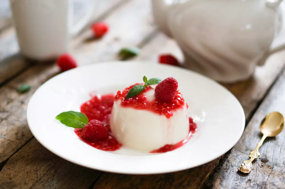 Delicious italian dessert panna cotta with raspberry sauce and mint / Foto: Ehaurylik