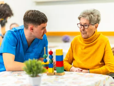 Young male nurse engages with an elderly woman, using colorful cognitive games as part of her therapy in a nursing home environment / Foto: Unaihuiziphotography