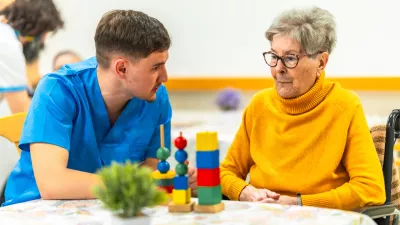 Young male nurse engages with an elderly woman, using colorful cognitive games as part of her therapy in a nursing home environment / Foto: Unaihuiziphotography