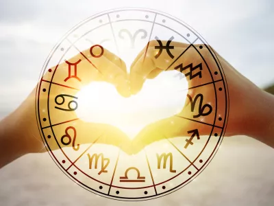The hands of women and men are the heart shape with the sun light passing through the hands have astrological symbols / Foto: Sarayut Getty Images