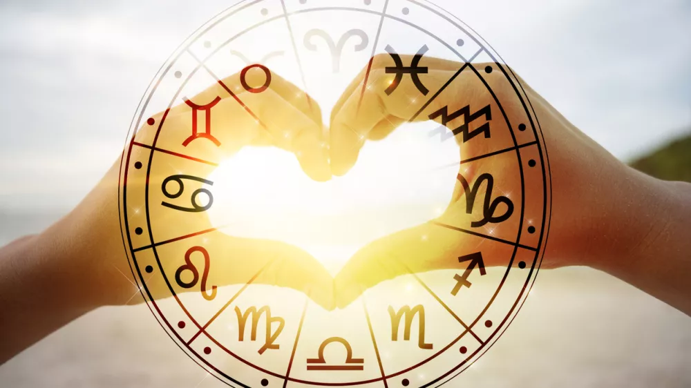 The hands of women and men are the heart shape with the sun light passing through the hands have astrological symbols / Foto: Sarayut Getty Images