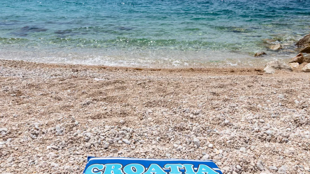 Towel Croatia on the pebbly beach of Mandre, Pag island, Croatia / Foto: Elena Estell&eacute;s Getty Images