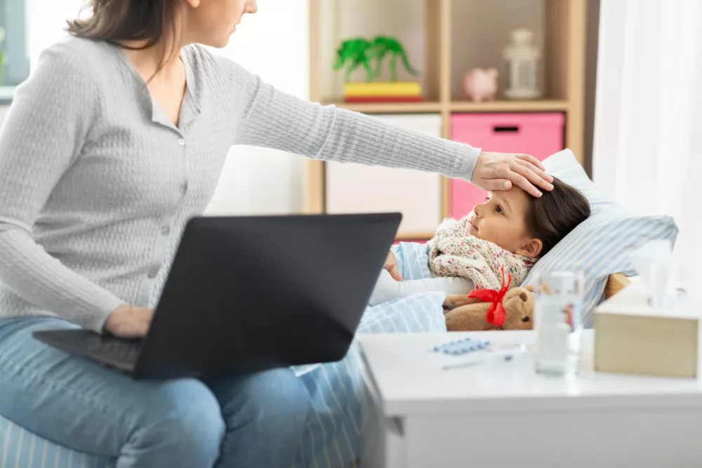 family, health and people concept - ill daughter and mother with laptop computer at home / Foto: Dolgachov Getty Images