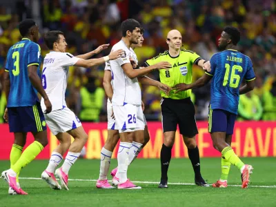 Soccer Football - FIFA World Cup 2026 - Group K - Uzbekistan v Colombia - Estadio Azteca, Mexico City, Mexico - June 17, 2026 Referee Anthony Taylor reacts with Uzbekistan's Jakhongir Urozov and Colombia's Jefferson Lerma REUTERS/Raquel Cunha