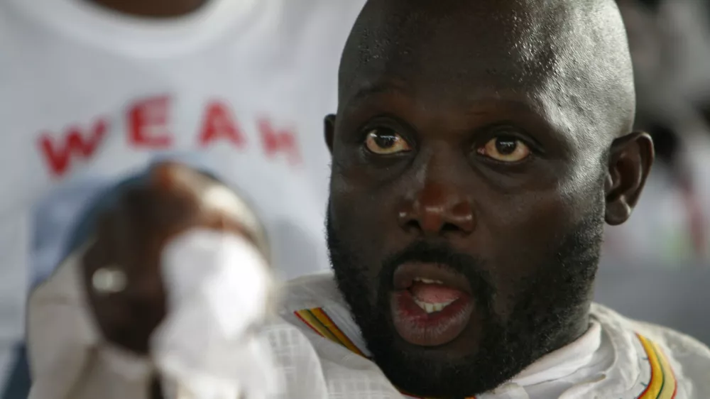 Former international soccer star and presidential hopeful George Weah gestures during a campaign rally for the Congress for Democratic Change at his headquarters in Monrovia October 8, 2005. Tens of thousands of supporters brought Monrovia to a standstill on Saturday as the millionaire soccer star held a final campaign rally before Liberia's first post-war elections.  REUTERS/Luc Gnago