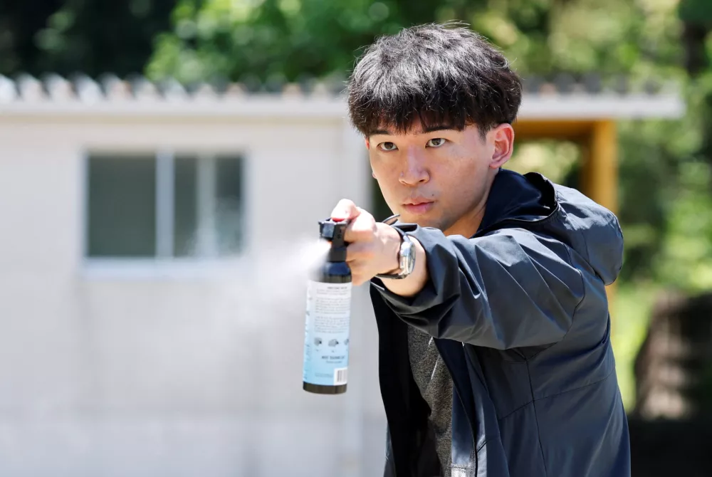 A participant uses a bear spray during an emergency response drill simulating a bear intrusion in Yaita, Tochigi Prefecture, Japan, June 17, 2026. REUTERS/Kim Kyung-Hoon