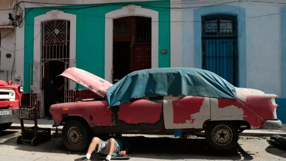 A man works on a classic American car in Havana, Cuba, Wednesday, June 17, 2026. (AP Photo/Jorge Luis Banos)