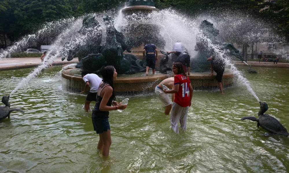 Young people cool off in the Fontaine de l'Observatoire fountain as temperatures rise in Paris and a heatwave hits a large part of France, June 18, 2026. REUTERS/Abdul Saboor