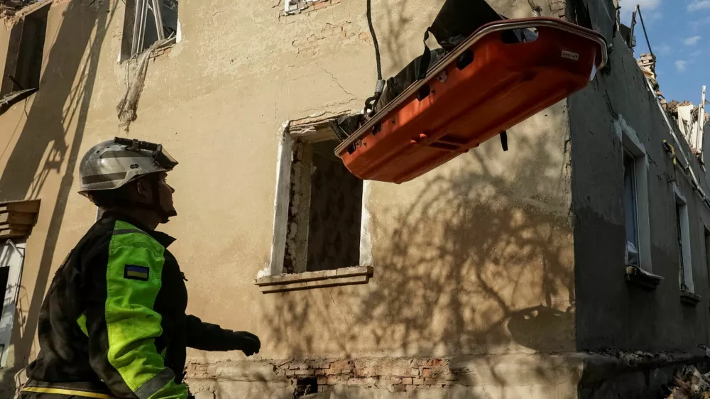 Rescuers use a crane to carry the bodies of people found under debris of an apartment building which was hit by a Russian air strike, amid Russia's attack on Ukraine, in Kharkiv, Ukraine June 20, 2026. REUTERS/Sofiia Gatilova