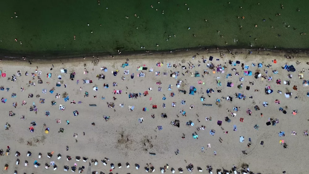 People visit the beach of the Baltic Sea during hot weather in Travemuende, Germany, Saturday, June 20, 2026. (AP Photo/Michael Probst)