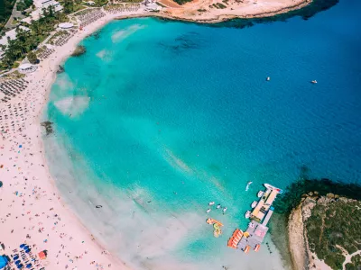 Beautiful beach on Mediterranean Sea with many tourists on sunny day, drone shot