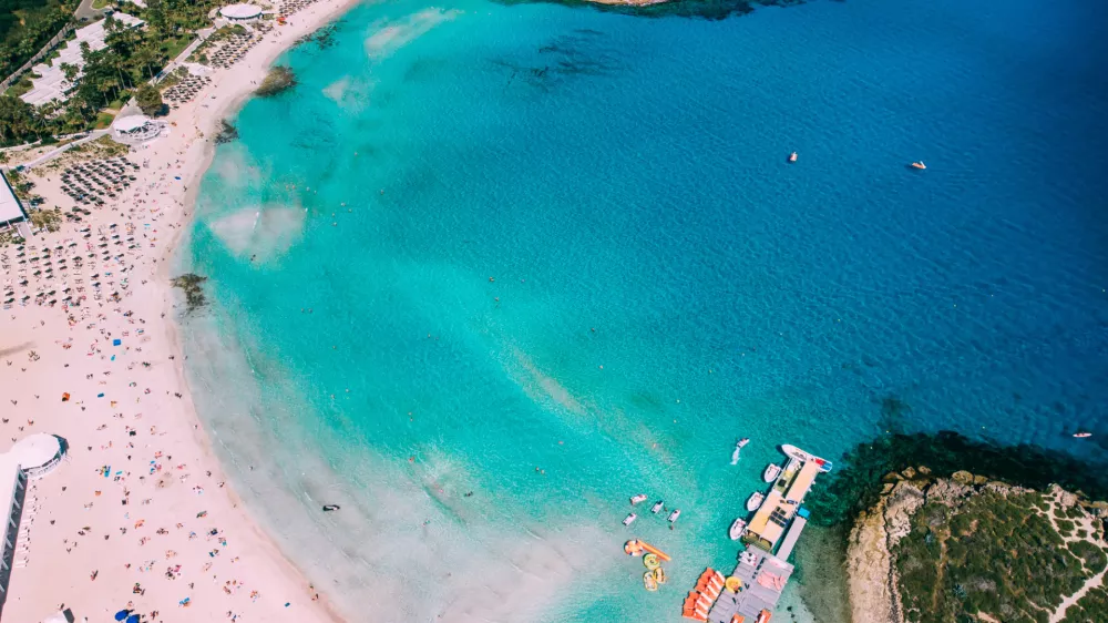 Beautiful beach on Mediterranean Sea with many tourists on sunny day, drone shot