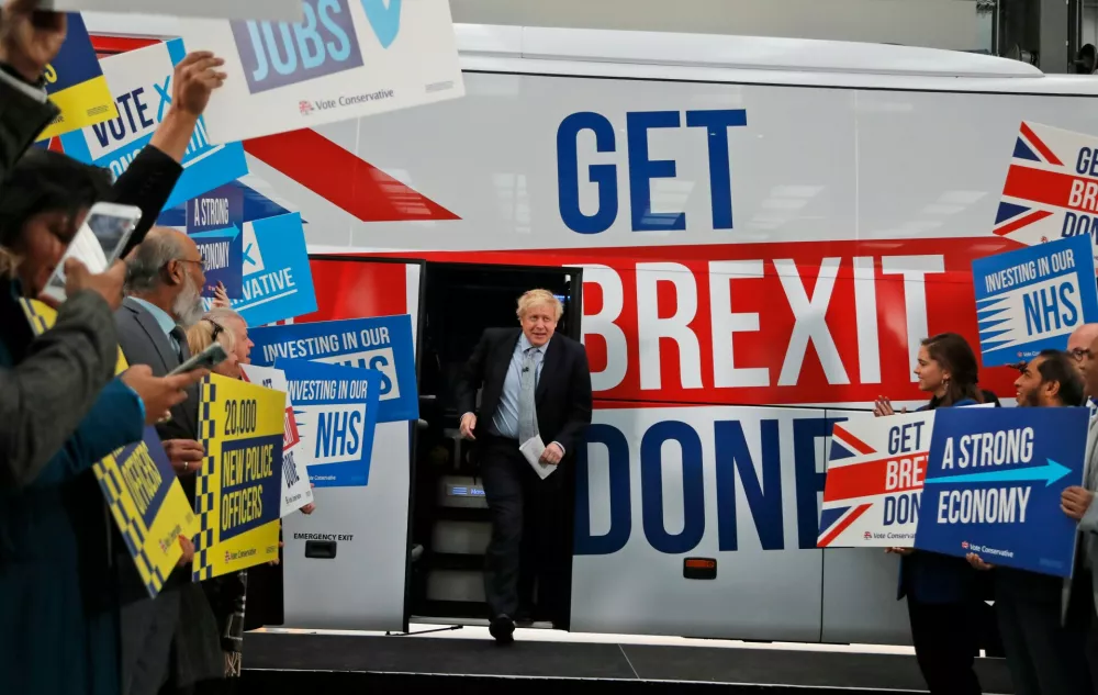 FILE - Britain's Prime Minister Boris Johnson addresses his supporters prior to boarding his General Election campaign trail bus in Manchester, England, Friday, Nov. 15, 2019. (AP Photo/Frank Augstein, Pool, File)