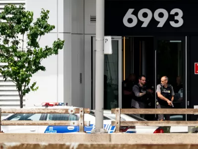 Montreal police exit a building at the scene of a shooting in Montreal on Monday, June 22, 2026. (Christopher Katsarov/The Canadian Press via AP) 