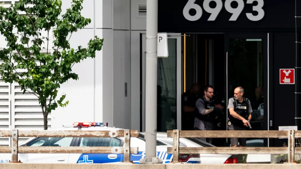 Montreal police exit a building at the scene of a shooting in Montreal on Monday, June 22, 2026. (Christopher Katsarov/The Canadian Press via AP) 