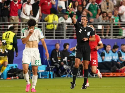 Soccer Football - FIFA World Cup 2026 - Group J - Jordan v Algeria - San Francisco Bay Area Stadium, Santa Clara, California, U.S. - June 22, 2026 Referee Slavko Vincic shows a yellow card to Algeria's Ramiz Zerrouki IMAGN IMAGES via Reuters/David Gonzales