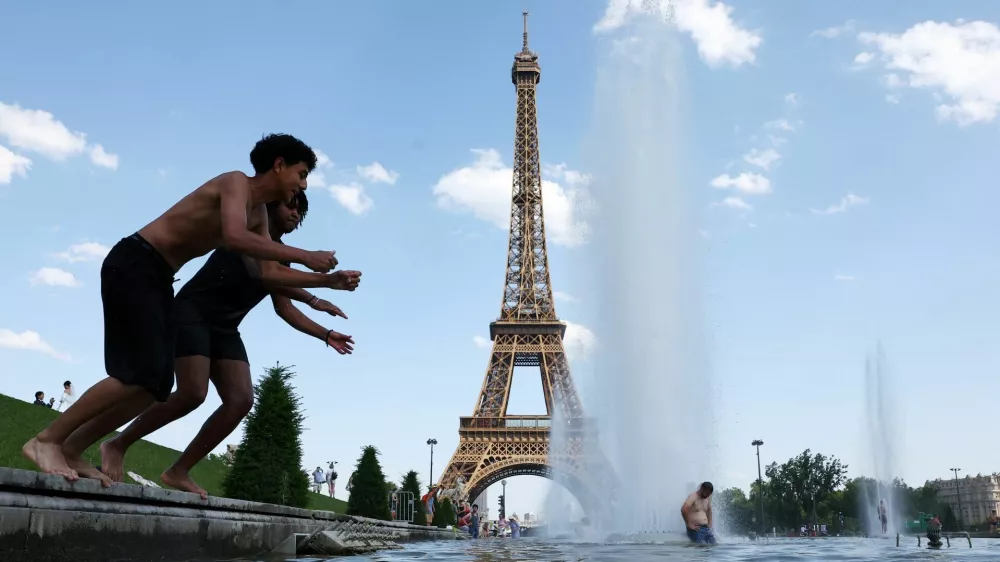 People cool off in the Trocadero Fountain next to the Eiffel Tower in Paris as temperatures rise during a heatwave affecting a large part of France, June 22, 2026. REUTERS/Abdul Saboor
