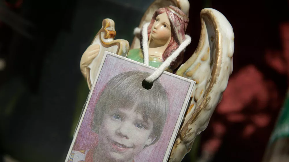 FILE - A photograph of Etan Patz hangs on an angel figurine, as part of a makeshift memorial in New York, May 28, 2012. (AP Photo/Mark Lennihan, File)