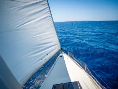 View from the mast down to the bow of a sailing yacht moving under full sails near Croatia. Freedom, adventure, yachting lifestyle and dynamic sea travel. High quality photo