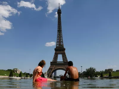 People cool off in the Trocadero Fountain next to the Eiffel Tower in Paris as temperatures rise during a heatwave affecting a large part of France, June 22, 2026. REUTERS/Abdul Saboor