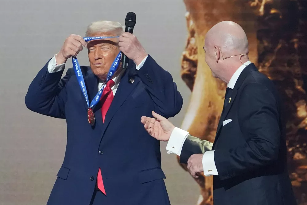 FILE - President Donald Trump puts on the inaugural FIFA Peace Prize presented to him by FIFA President Gianni Infantino during the 2026 FIFA World Cup draw at the Kennedy Center in Washington, Dec. 5, 2025. (AP Photo/Evan Vucci, File) / Foto: Evan Vucci