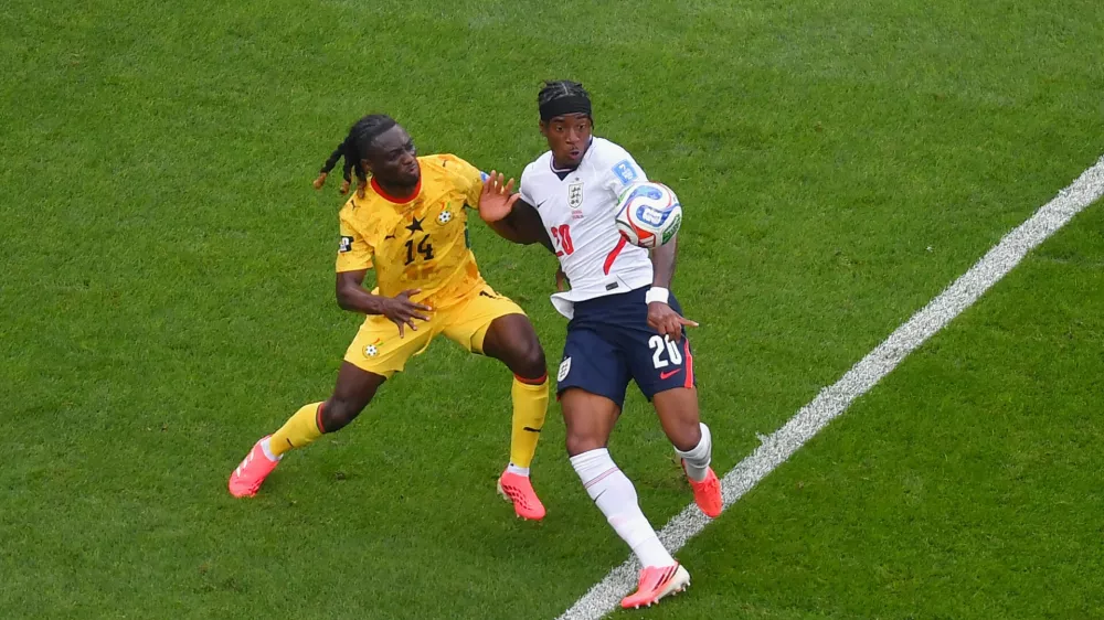 England's Noni Madueke (20) tries to keep the ball away from Ghana's Gideon Mensah (14) during the second half of a World Cup Group L soccer match in Foxborough, Mass., near Boston, Tuesday, June 23, 2026. (AP Photo/Steven Senne)