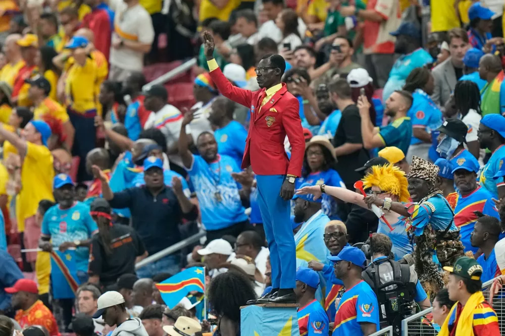 Congo supporter Michel Nkuka Mboladinga poses as a statue of the country's assassinated independence hero Patrice Lumumba ahead of the World Cup Group K soccer match between Colombia and Congo in Zapopan, near Guadalajara, Mexico, Tuesday, June 23, 2026. (AP Photo/Fernando Llano)