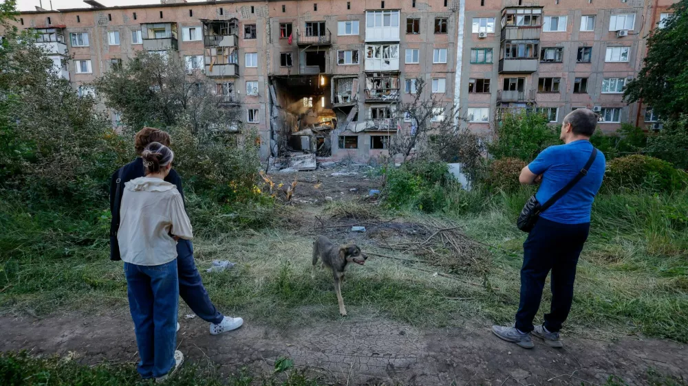 People look at a heavily damaged multi-storey residential building following an overnight attack, what Russian-installed authorities called a Ukrainian drone strike, in the course of the Russia-Ukraine conflict in the town of Horlivka (Gorlovka) in the Donetsk region, a Russian-controlled area of Ukraine, June 24, 2026. REUTERS/Alexander Ermochenko