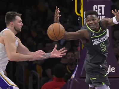 Apr 19, 2025; Los Angeles, California, USA; Los Angeles Lakers guard Luka Doncic (77) and Minnesota Timberwolves guard Anthony Edwards (5) reach for a loose ball in the first half at Crypto.com Arena. Mandatory Credit: Jayne Kamin-Oncea-Imagn Images