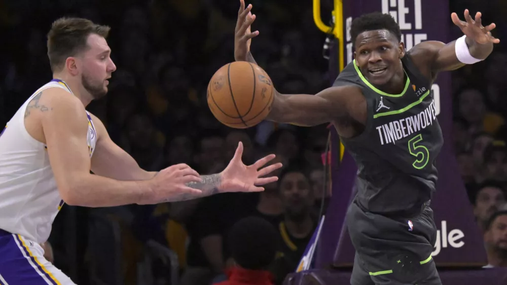 Apr 19, 2025; Los Angeles, California, USA; Los Angeles Lakers guard Luka Doncic (77) and Minnesota Timberwolves guard Anthony Edwards (5) reach for a loose ball in the first half at Crypto.com Arena. Mandatory Credit: Jayne Kamin-Oncea-Imagn Images