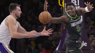 Apr 19, 2025; Los Angeles, California, USA; Los Angeles Lakers guard Luka Doncic (77) and Minnesota Timberwolves guard Anthony Edwards (5) reach for a loose ball in the first half at Crypto.com Arena. Mandatory Credit: Jayne Kamin-Oncea-Imagn Images