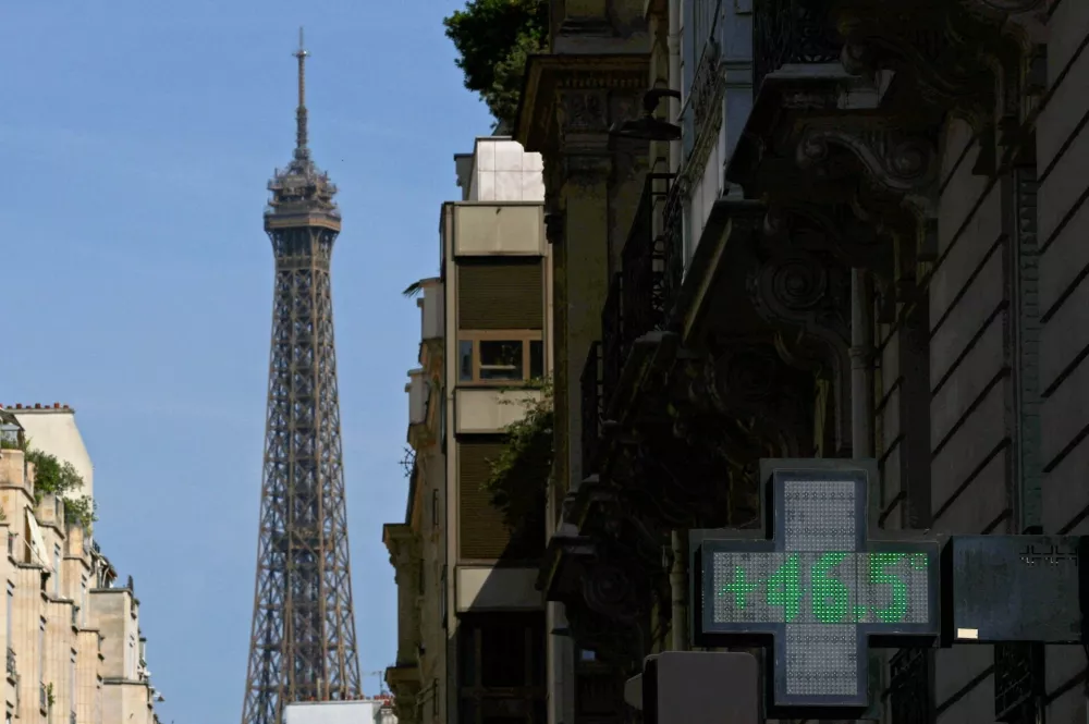 A pharmacy sign displays a temperature of 46.5 degrees Celsius on a street with the Eiffel Tower in the background as temperatures rise in Paris, during a heatwave affecting a majority of the country, France, June 25, 2026. REUTERS/Gonzalo Fuentes   TPX IMAGES OF THE DAY