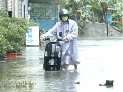 A man with a scooter moves in the floodwater during heavy rains caused by the nearby passing of typhoon Mekkhala, as it heads towards Japan, in Kaohsiung, Taiwan, June 25, 2026. CTS via REUTERS TV/via REUTERS  THIS IMAGE HAS BEEN SUPPLIED BY A THIRD PARTY. NO RESALES. NO ARCHIVES. TAIWAN OUT. NO COMMERCIAL OR EDITORIAL SALES IN TAIWAN. MANDATORY CREDIT.