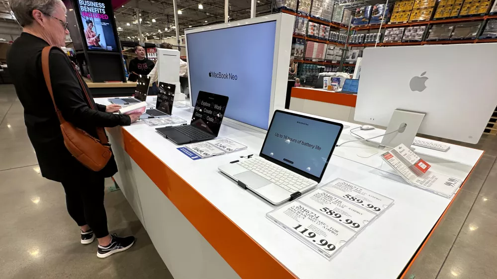 FILE - A shopper looks over Apple MacBook laptops on display in a Costco warehouse on June 2, 2026, in Sheridan, Colo. (AP Photo/David Zalubowski, File)