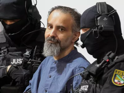 Suspect Taleb al-Abdulmohsen, a doctor from Saudi Arabia who faces charges of murder, attempted murder and dangerous interference with road traffic, looks on while being escorted by security officers as he attends his trial for the Magdeburg Christmas market attack, at a regional court in Magdeburg, Germany, June 26, 2026. REUTERS/Fabrizio Bensch