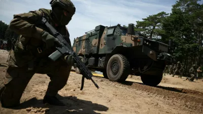 A Polish soldier kneels next to a military vehicle during the Bursztynowy Obronca-26 (Amber Defender-26) military exercise at the training ground in Klusy, Poland, June 24, 2026. REUTERS/Kacper Pempel