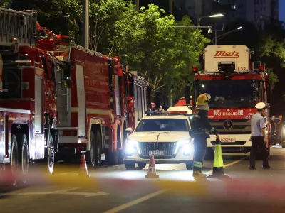 Rescue workers stand near firetrucks behind a cordon line on a road next to CITIC Tower, also known as China Zun, in Beijing, China June 26, 2026. REUTERS/Maxim Shemetov