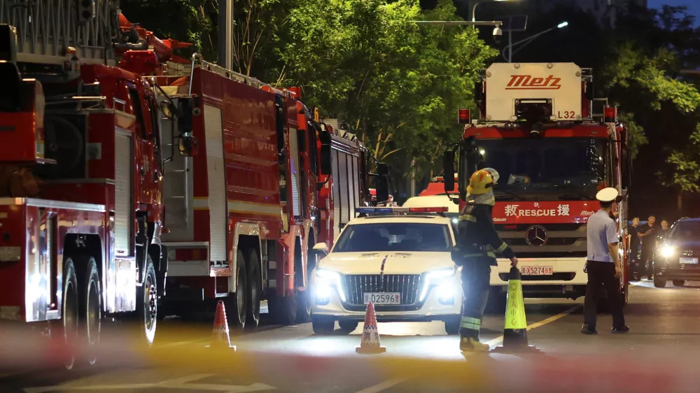 Rescue workers stand near firetrucks behind a cordon line on a road next to CITIC Tower, also known as China Zun, in Beijing, China June 26, 2026. REUTERS/Maxim Shemetov