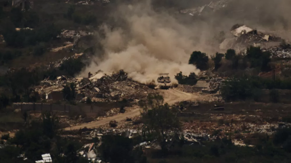An Israeli tank moves past destroyed buildings in southern Lebanon as seen from northern Israel, Friday, June 26, 2026. (AP Photo/Leo Correa)