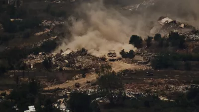 An Israeli tank moves past destroyed buildings in southern Lebanon as seen from northern Israel, Friday, June 26, 2026. (AP Photo/Leo Correa)
