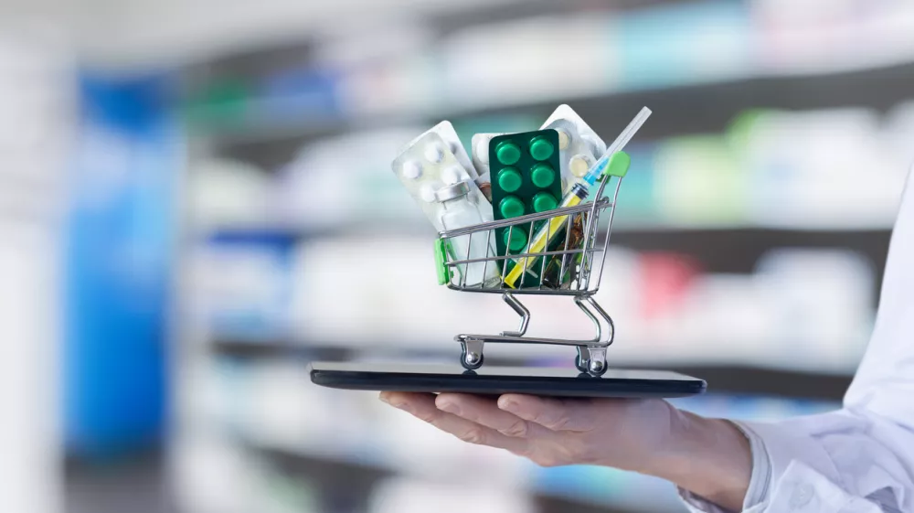 The concept of online medicine trading. The doctor shows a shopping cart with medicines on his tablet.