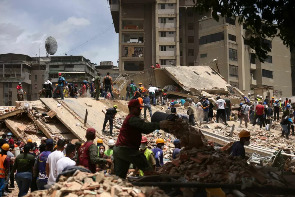 People search for casualties amid the rubble of a collapsed building, in the aftermath of earthquakes in Caracas, Venezuela, June 25, 2026. REUTERS/Leonardo Fernandez Viloria / Foto: Leonardo Fernandez Viloria