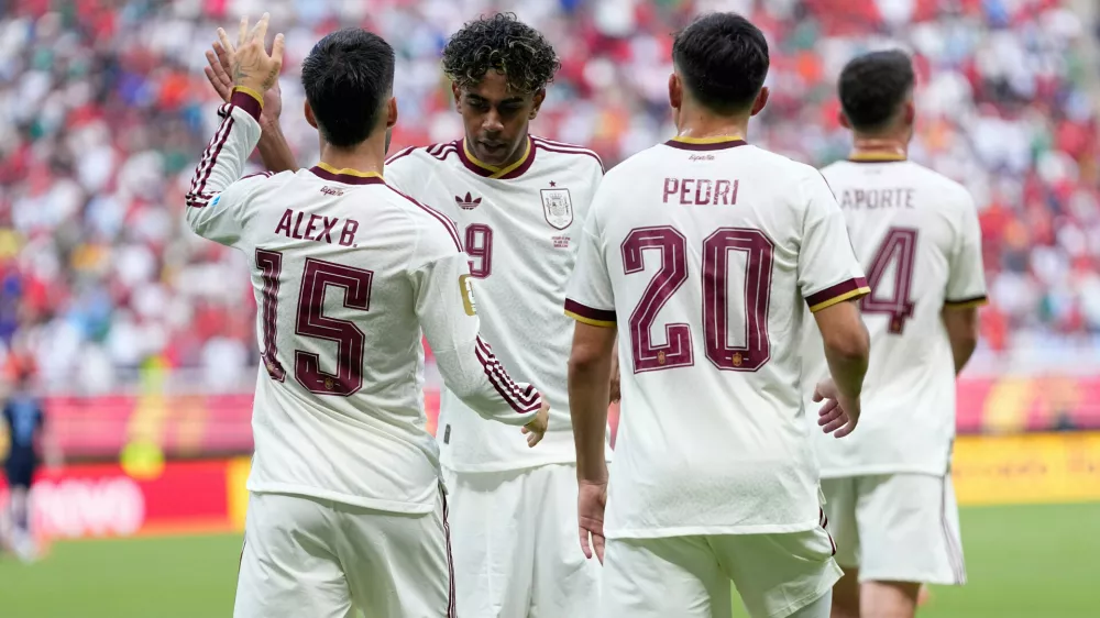 Spain's Lamine Yamal, second from left, congrats Alex Baena (15) after scored the opening goal during the World Cup Group H soccer match between Uruguay and Spain in Zapopan, near Guadalajara, Mexico, Friday, June 26, 2026. (AP Photo/Natacha Pisarenko)