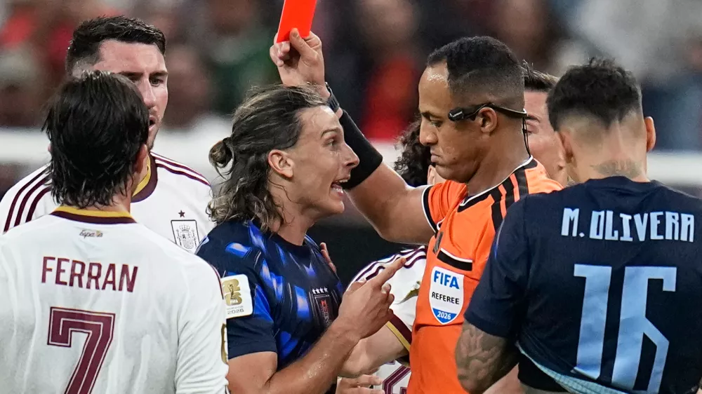 Referee Ismail Elfath shows a red card to Uruguay's Agustin Canobbio during the World Cup Group H soccer match between Uruguay and Spain in Zapopan, near Guadalajara, Mexico, Friday, June 26, 2026. (AP Photo/Ricardo Mazalan)