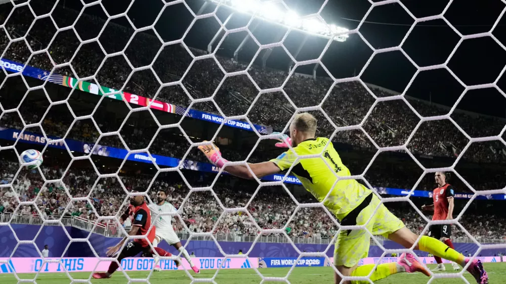 Algeria's Riyad Mahrez (7) scores their second goal past Austria goalkeeper Alexander Schlager (1) during the World Cup Group L soccer match between Croatia and Ghana in Philadelphia, Saturday, June 27, 2026. (AP Photo/Charlie Riedel)