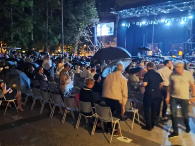 Trenutek, ko so obiskovalci slavnostnega odprtja 74. Ljubljana Festivala začeli vstajati, odpirati dežnike in zapu&scaron;čati prizori&scaron;če na prostem na Kongresnem trgu. F Alenka &Scaron;ubic