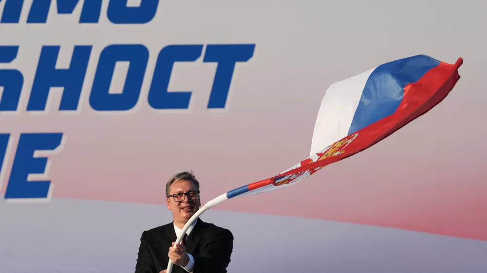 Serbian President Aleksandar Vucic waves a Serbian flag during a rally of the ruling Serbian Progressive Party (SNS) in Belgrade, Serbia, Saturday, June 27, 2026, where he announced that he will resign in the coming weeks. (AP Photo/Darko Vojinovic)