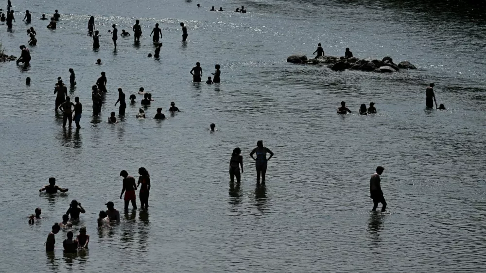 People enjoy the cool waters of the Isar during a heatwave in Munich, Germany, June 28, 2026. REUTERS/Angelika Warmuth